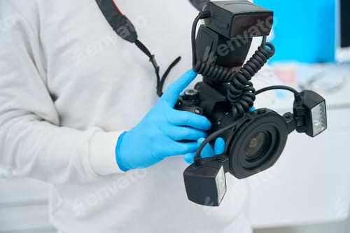 Preview: Doctor holding and showing portable dental x-ray camera