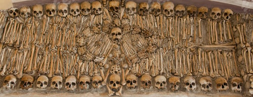 Preview: human skulls and bones in a wall