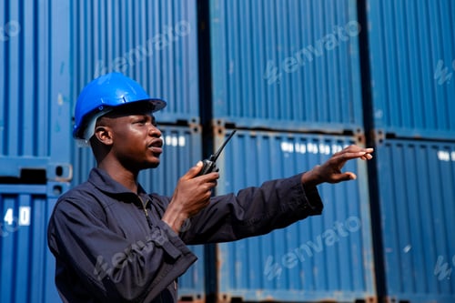 Preview: african amarican man worker working control loading freight containers at commercial shipping dock.