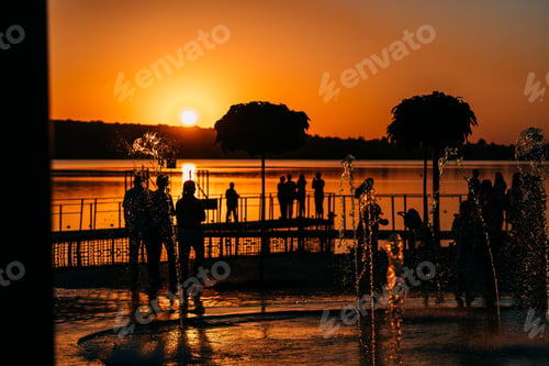 Preview: people spend leisure time on the river bank