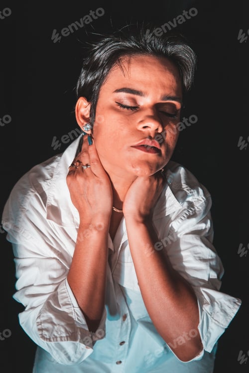 Preview: Portrait of a young brunette woman with an artistic expression on a black background