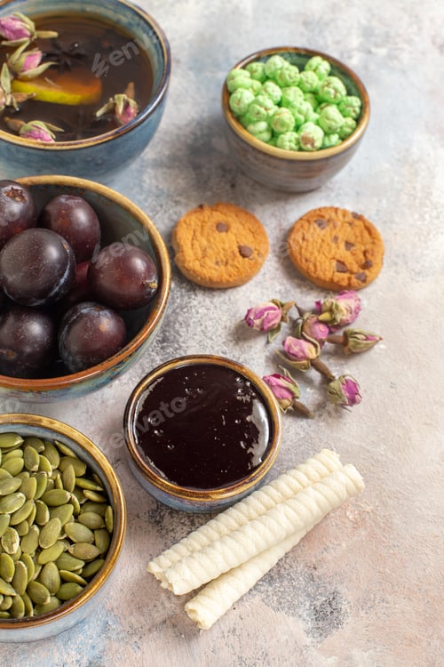 Preview: front view cup of tea with plums and candies on a light background dessert sweet biscuit
