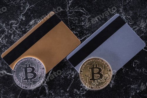 Preview: top view of credit cards and bitcoins on dark marble surface
