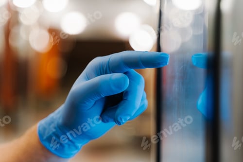 Preview: Close up hand in rubber disposable glove types on touch screen