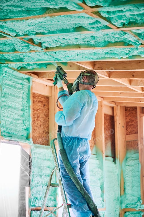 Preview: Worker spraying polyurethane foam for insulating wooden frame house.