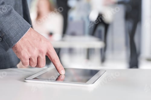 Preview: Businessman pointing on digital tablet in office