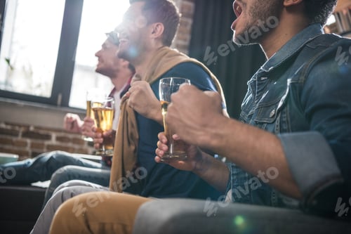 Preview: diverse group of young people drinking beer at home, young people having fun concept