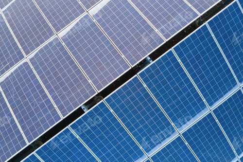Preview: Aerial view building roof with rows of blue solar photovoltaic panels for producing clean ecological