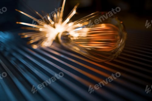 Preview: The incandescent lamp does not shine brightly and sparks fall on the metal surface in a dark room