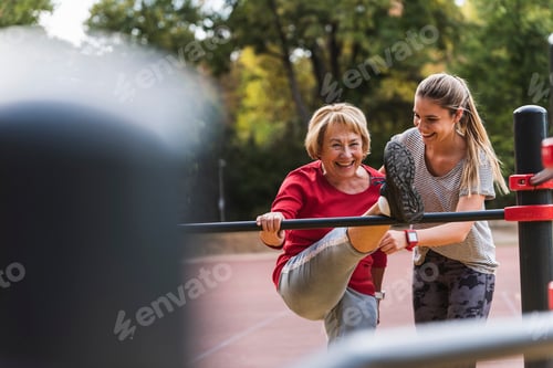 Preview: Grandmother and granddaughter training on bars in a park
