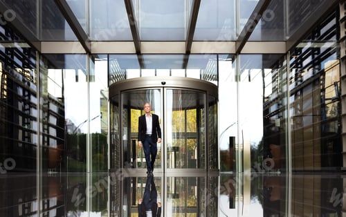 Preview: Business man walking out of office buildings. Copy space.