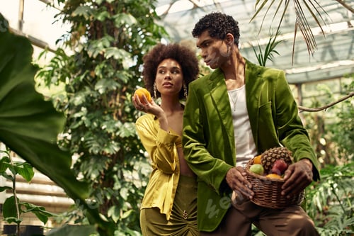 Preview: Young couple sharing intimate moments surrounded by lush greenery in a vibrant greenhouse setting