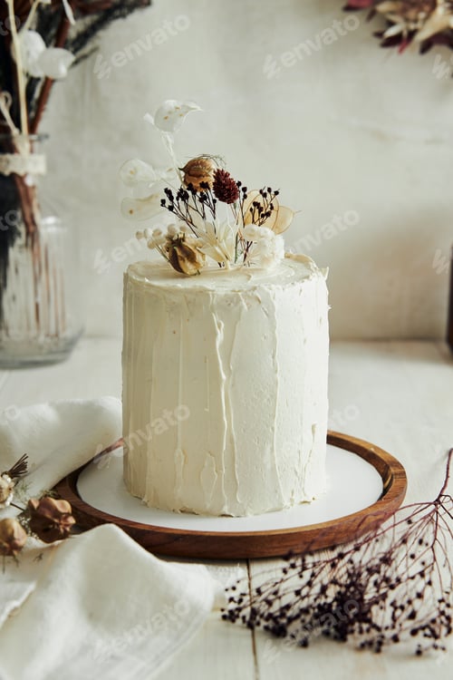 Preview: Closeup shot of delicious Boho ombre cake with dry flowers on a white table
