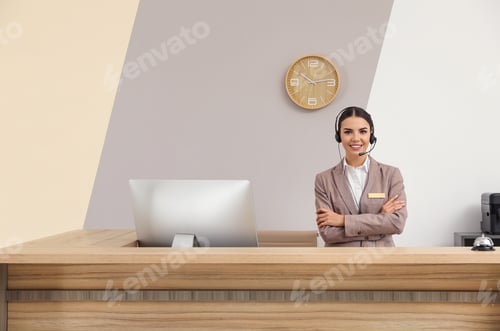 Preview: Portrait of receptionist working at desk in modern hotel