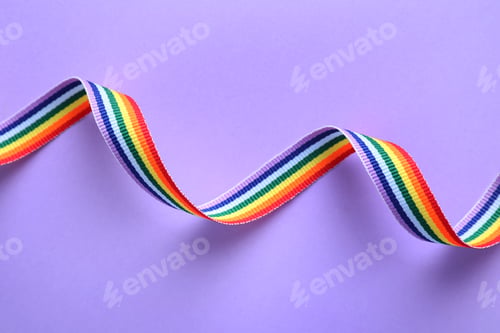 Preview: Bright rainbow ribbon on color background, top view. Symbol of gay community