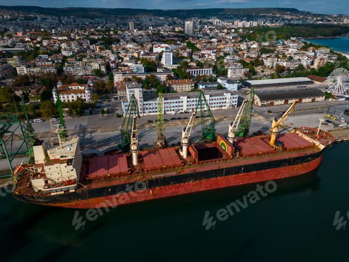Preview: cargo ship or bulk carrier loaded to the brim with grain is preparing for departure, working sailors