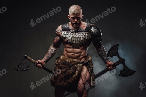 Preview: Brutal tattooed warrior wearing light armour and fur holding axes in dark studio