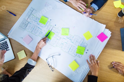 Preview: Architects discussing blueprint in office