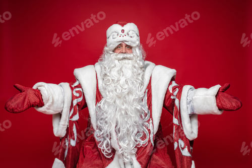 Preview: Welcome gesture of Santa Claus on red studio background, xmas and new year advertising photography