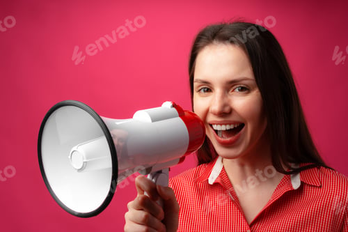 Preview: Young brunette woman shouting in megaphone against pink background