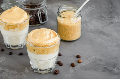 Preview: Iced Dalgona Coffee, a trendy fluffy creamy whipped coffee with milk in a glass on a dark background