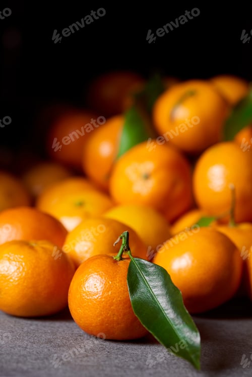 Preview: selective focus of sweet orange tangerine near clementines with green leaves