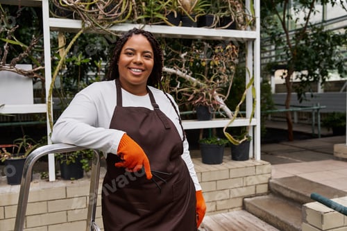 Preview: Gardener enjoying her time in a vibrant greenhouse filled with lush plants and greenery