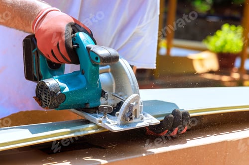 Preview: Worker uses circular saw to cut vinyl siding in construction area