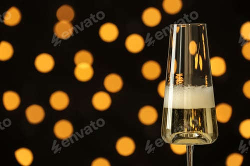 Preview: Glass of champagne against blurred lights. Space for text
