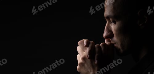 Preview: Portrait of a handsome man praying over gray background