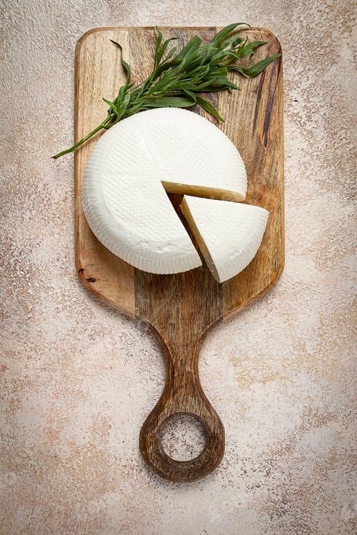 Preview: Head of Georgian cheese, Imereti variety, top view, on a cutting board,