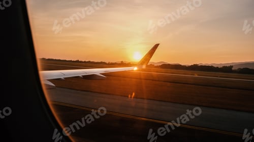Preview: view from airplane window Seeing the wings of an plane with a sunset in golden hour