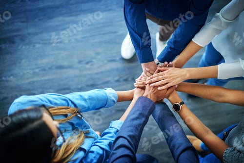 Preview: High angle shot of a group unrecognizable businesspeople joining their hands together in unity