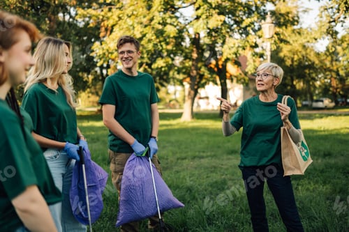 Preview: Group of volunteers collecting garbage in park are listening to their team leader