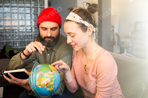 Preview: Happy young man and woman with globe choosing place for summer rest at leisure. Family travel.
