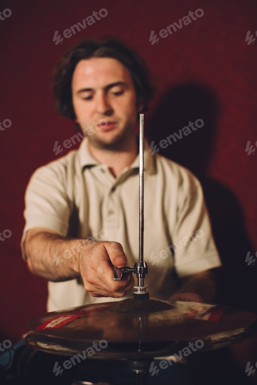 Preview: Drummer setting up a cymbal on a stand in a professional recording studio
