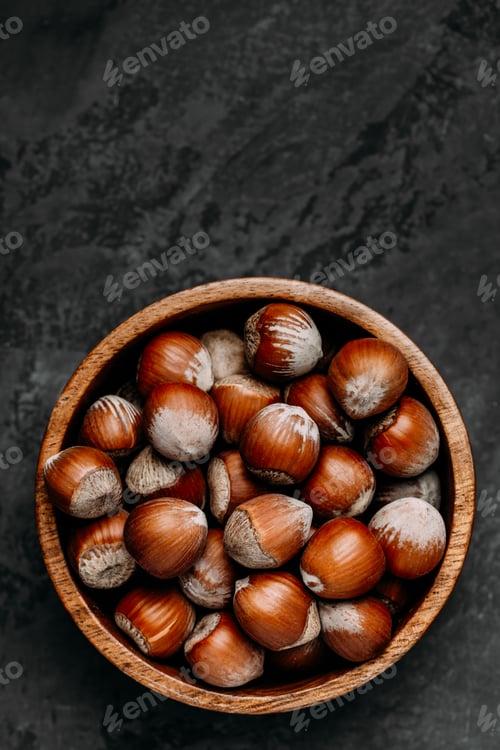 Preview: Hazelnuts. Whole Hazelnuts in wooden bowl on dark background