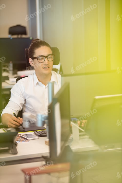 Preview: Designer using digitizer on office desk