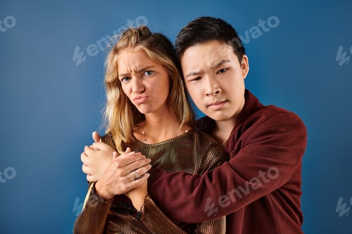 Preview: confused multiracial teenagers in vibrant attires hugging and looking at camera, friendship day