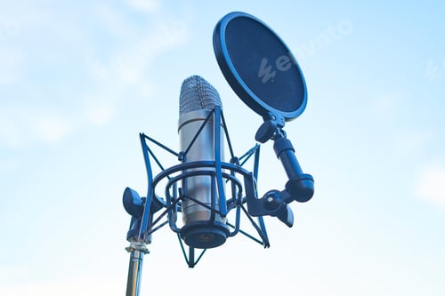 Preview: studio condenser microphone on sky background. Copy space