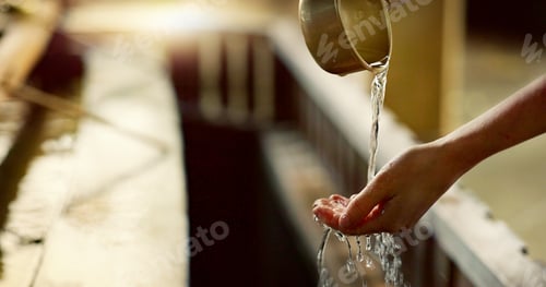 Preview: Shinto temple, closeup and washing hands with water in container for cleaning, faith and wellness.