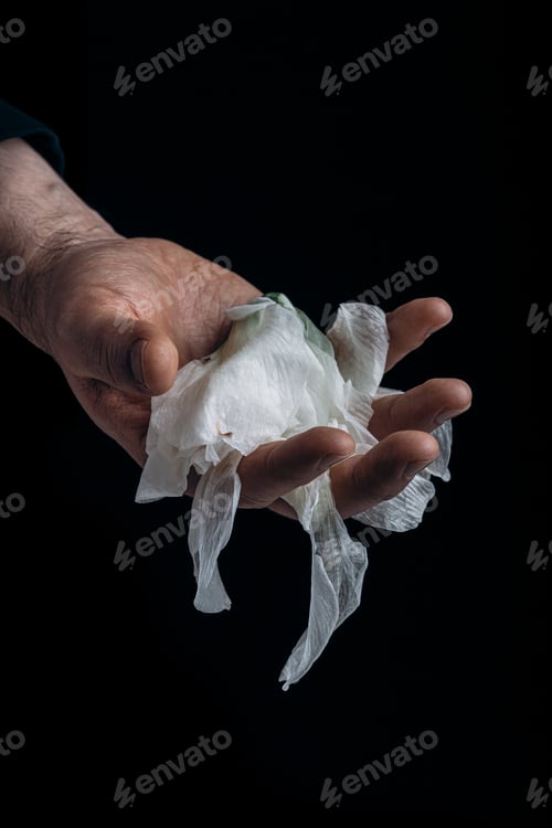 Preview: man's hand holding wilted flower, concept of melancholy sadness fatigue despair or depression