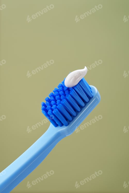 Preview: Blue toothbrush with toothpaste on a green background, close-up. Mint background.
