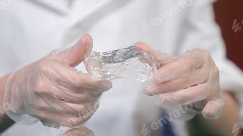 Preview: Natural stone amethyst or another mineral, stone. Wild amethyst in female hands in white gloves