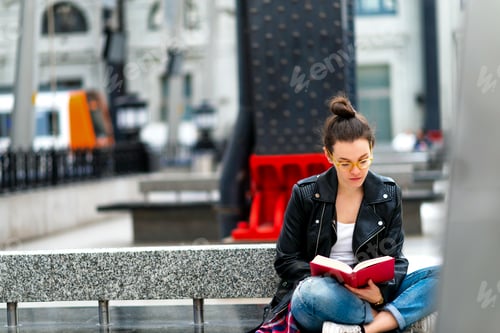 Preview: Woman reading book on bench
