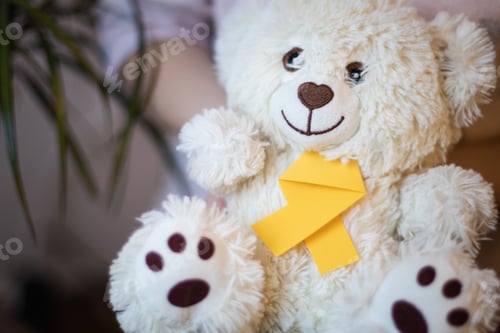 Preview: The girl holds in her hands a toy teddy bear with a yellow ribbon.