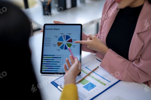 Preview: Two people are looking at a tablet with a pie chart on it