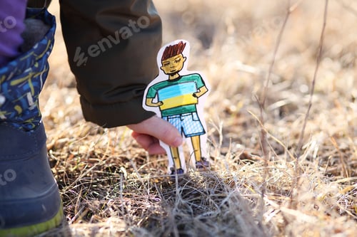 Preview: A small refugee boy from Ukraine with a drawing of the Ukrainian flag.