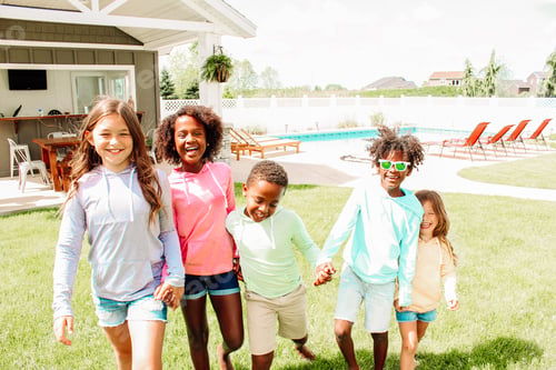 Preview: Smiling Children Hold Hands Outdoors on a Sunny Day