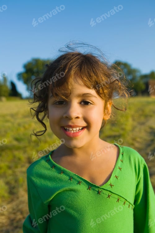 Preview: A young girl smiling outdoors on a sunny day